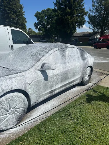 Foam wash covering a car outdoors